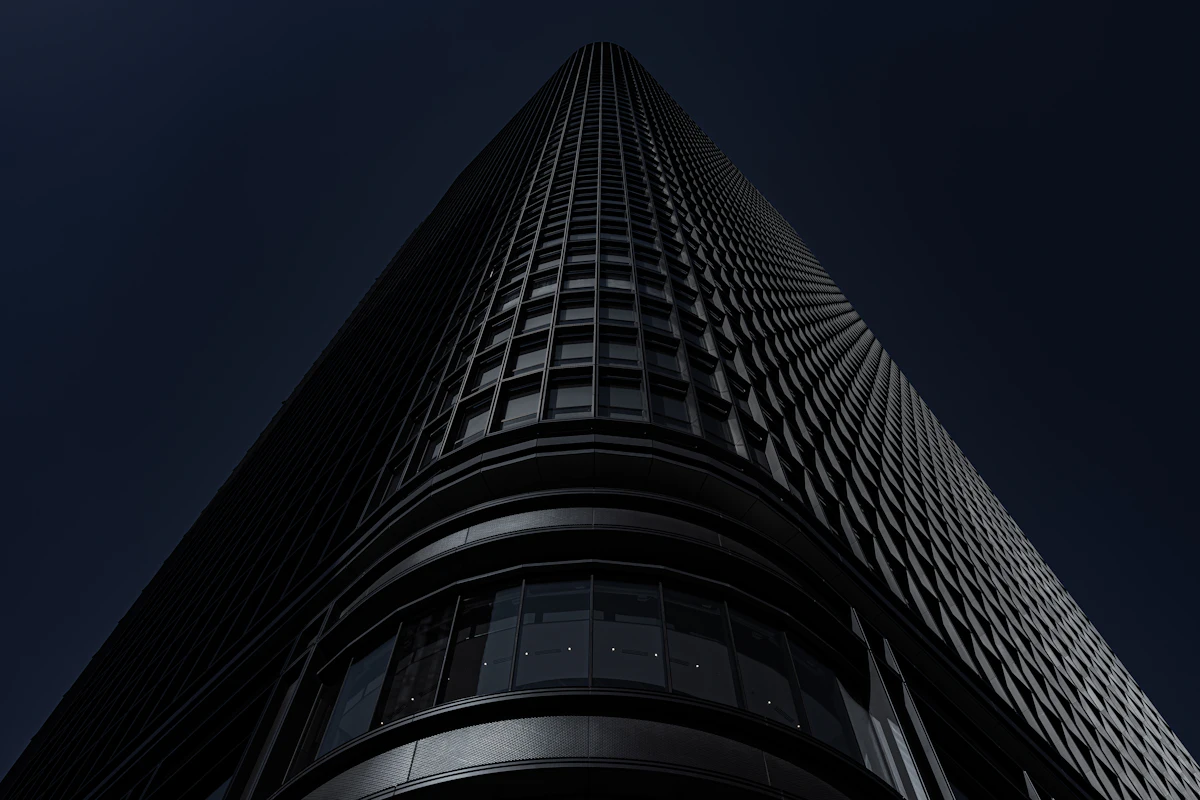 Looking up the glass facade of a city office tower at night